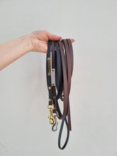 Load image into Gallery viewer, Black and brown leads in biothane, with gold and silver details.