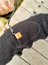 Load image into Gallery viewer, Dog wearing a black wool coat photographed from above to show the harness hole.

