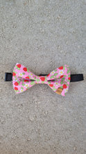 Load image into Gallery viewer, A dog bow tie with pink base, red strawberries, white flowers and green leaves.
