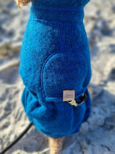 Load image into Gallery viewer, Close up of the back of a dog wearing a blue jumpsuit made of wool. There is a hole for the harness and a logo that reads &quot;Beans &amp; Sploot&quot;.
